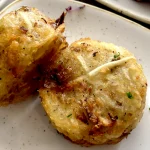Two crispy golden hash browns on a plate