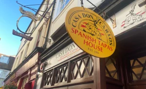 old fashioned yellow oval restaurant sign hanging outside building