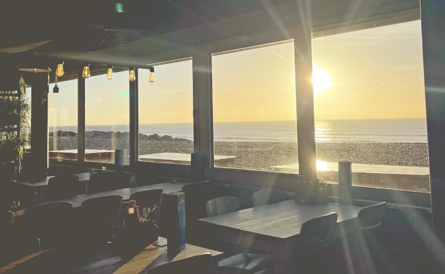 Dark interior shot of beach restaurant, with sun set and sun rays coming through the window